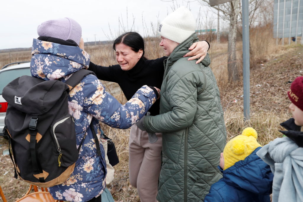 People comfort a woman following fleeing from Ukraine to Hungary, after Russia launched a massive military operation against Ukraine, at a border crossing in Beregsurany, Hungary, February 26, 2022. REUTERS/Bernadett Szabo